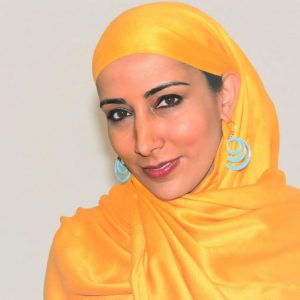 Headshot of Najeeba Syeed. Najeeba is wearing a yellow headscarf and blue spiral earrings.